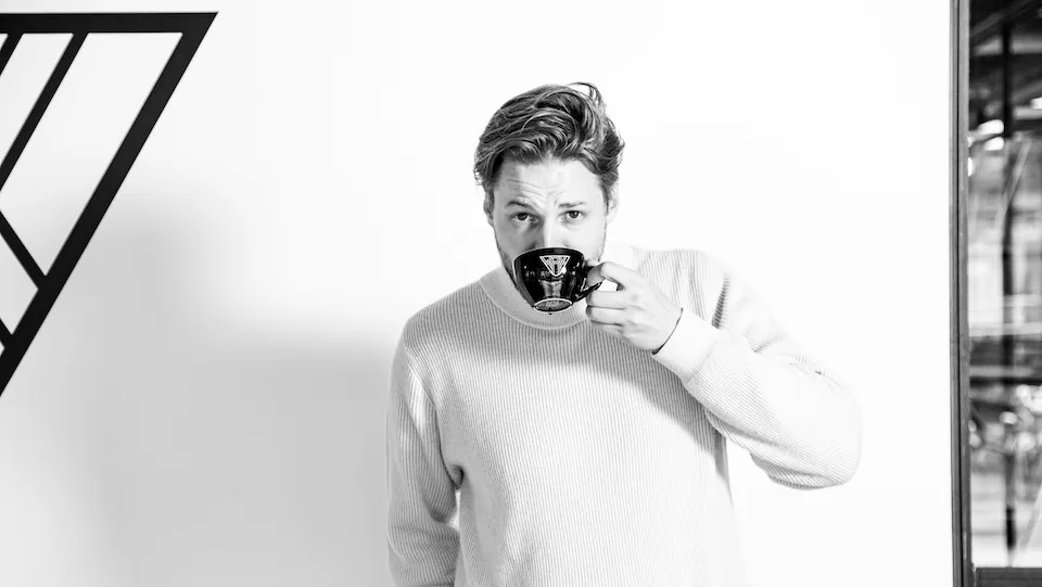 Mark Schoones drinkt uit een kopje en kijkt over de rand