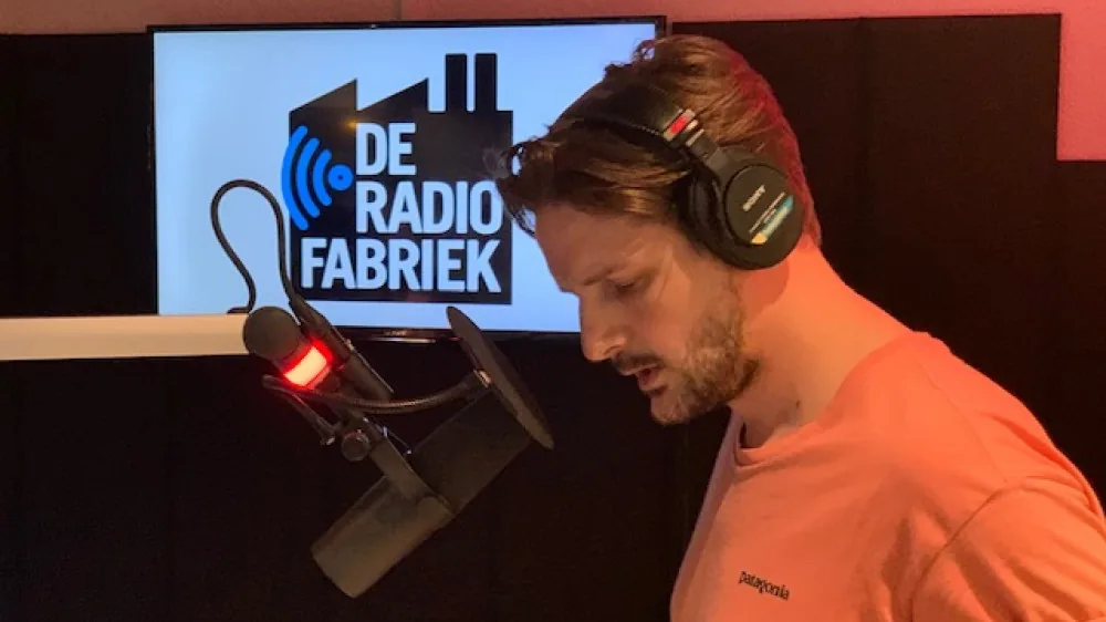 Mark Schoones achter de microfoon in een radiostudio